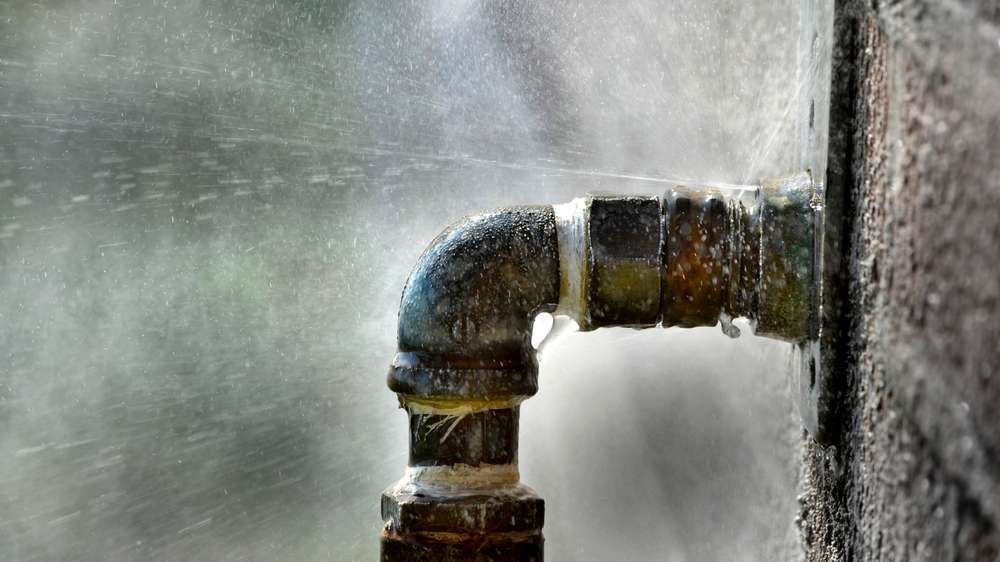 A close up of a water pipe with water coming out of it.