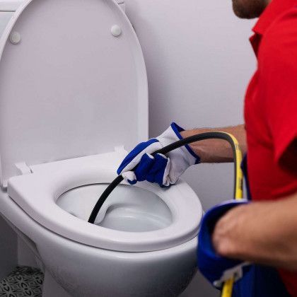 A man is fixing a sink with a pair of pliers.