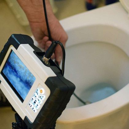 A man is fixing a sink with a pair of pliers.