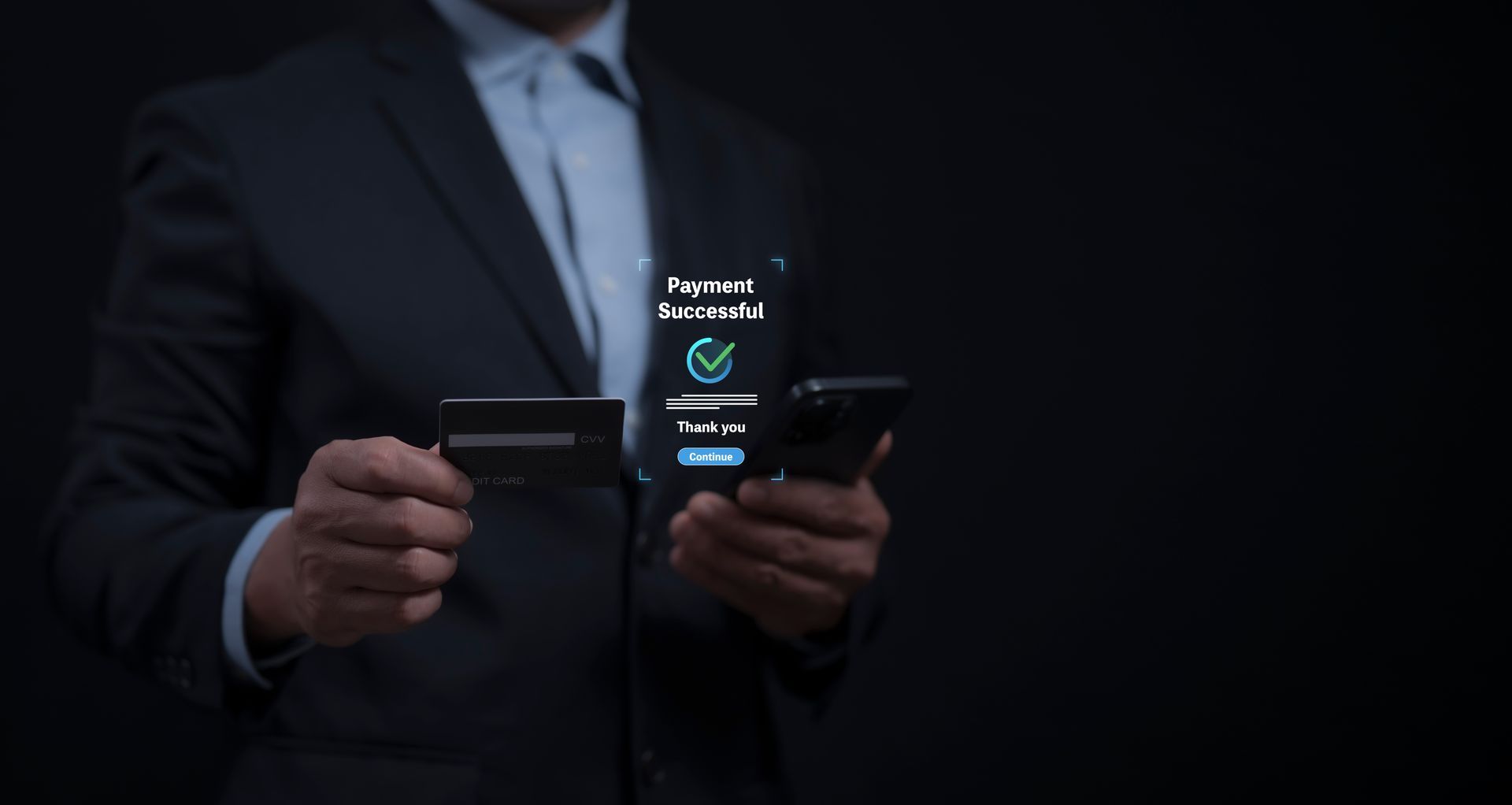 Man in suit holding a credit card and smartphone, purchase successful notification on the screen.