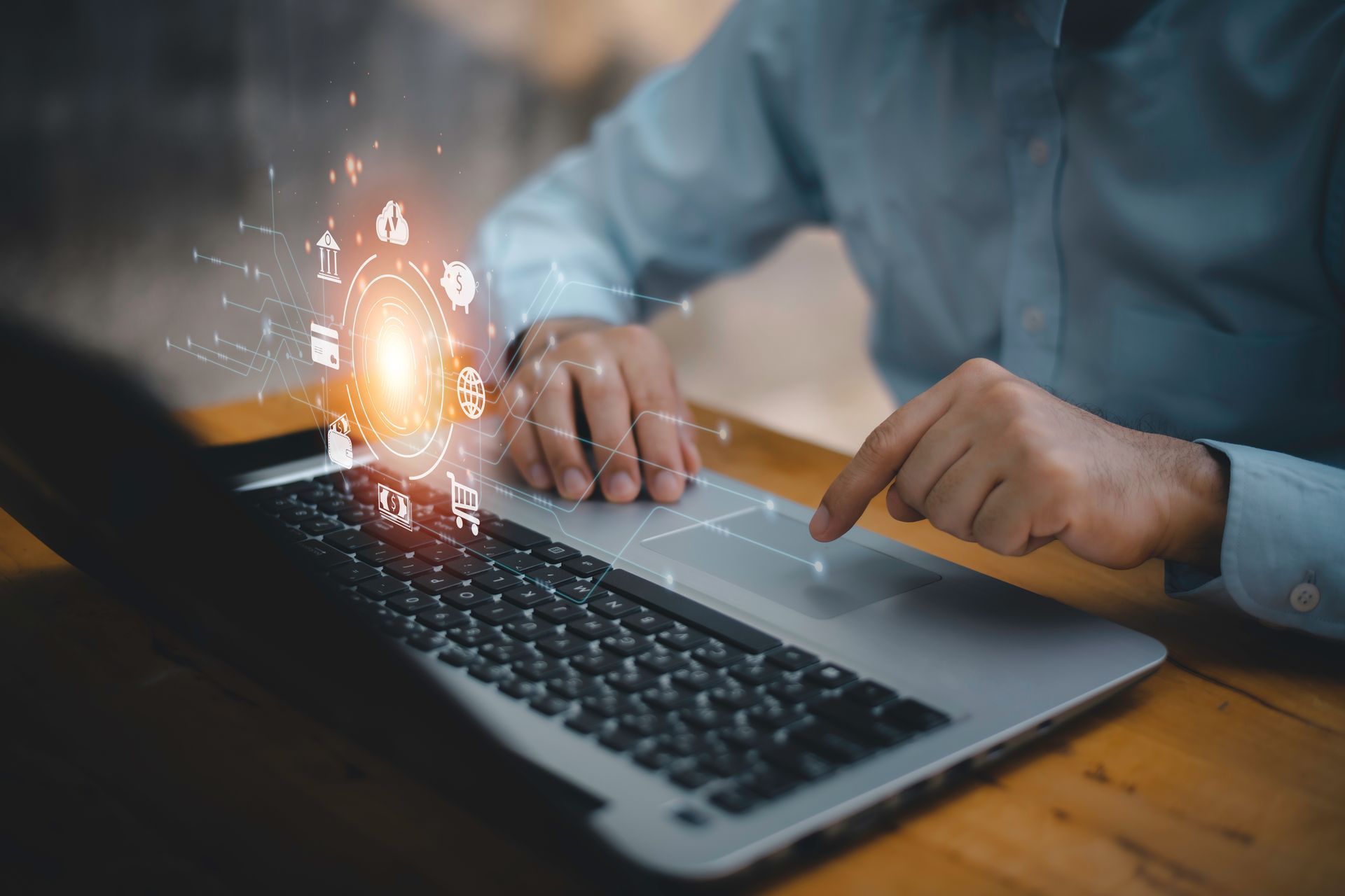 Person using laptop, digital icons hovering above the screen, indicating technology and data processing.