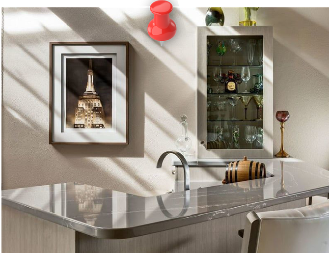 a picture of the empire state building hangs above a kitchen counter