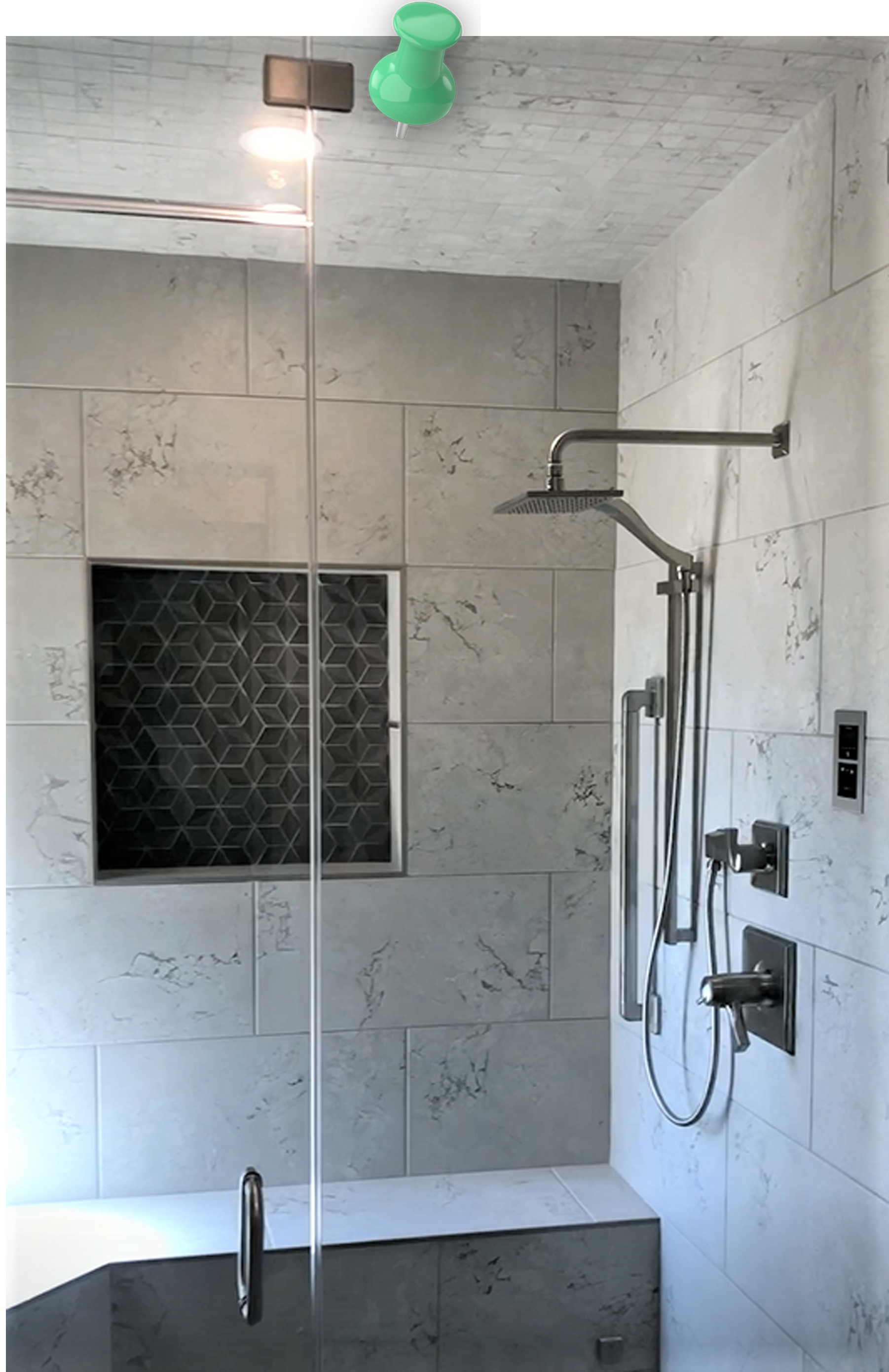 a bathroom with gray tiles and a shower head