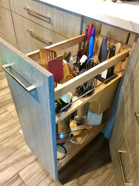 A kitchen drawer filled with utensils and pots and pans