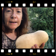 a woman is holding a large squash