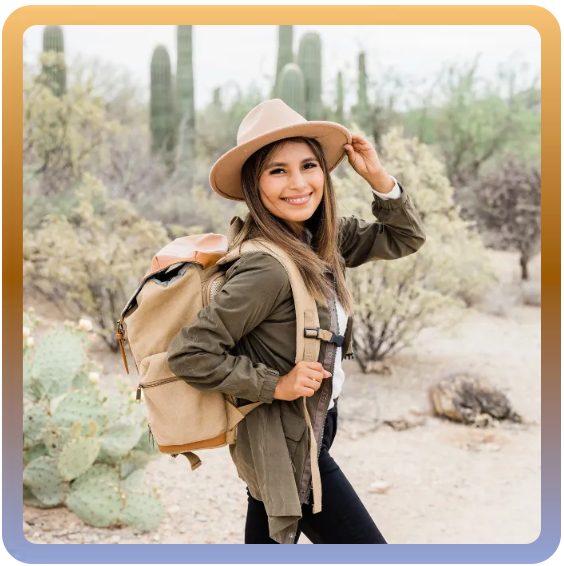 a woman wearing a hat and carrying a backpack in the desert