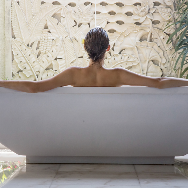 a woman sits in a bathtub with her arms outstretched