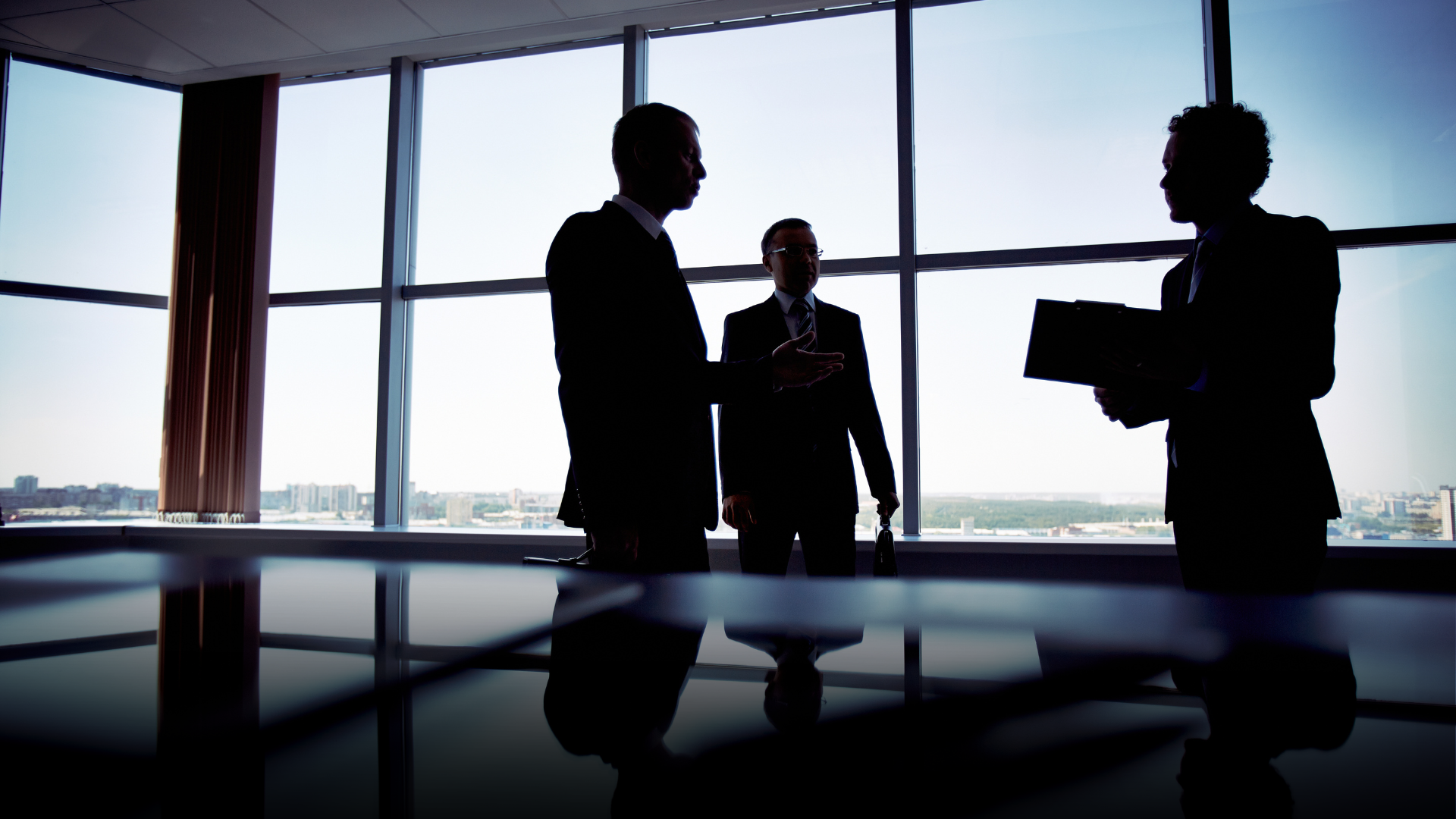 A group of business people standing in front of a window