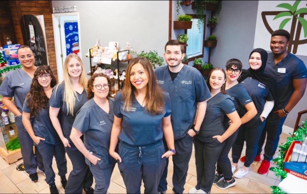 A group of people in scrubs are posing for a picture in a dental office.