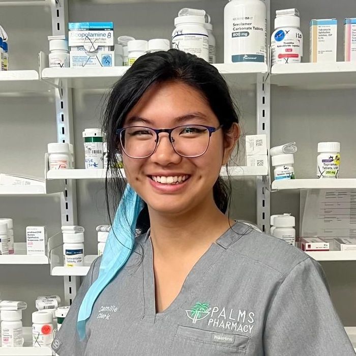 A woman in a palms pharmacy uniform is smiling