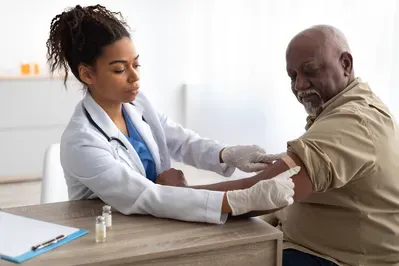 A doctor is giving an older man an injection in his arm.