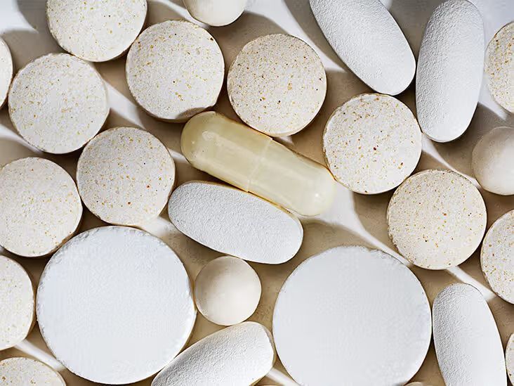 A pharmacist is looking at a tablet in a pharmacy.