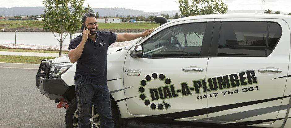 plumber on phone by car
