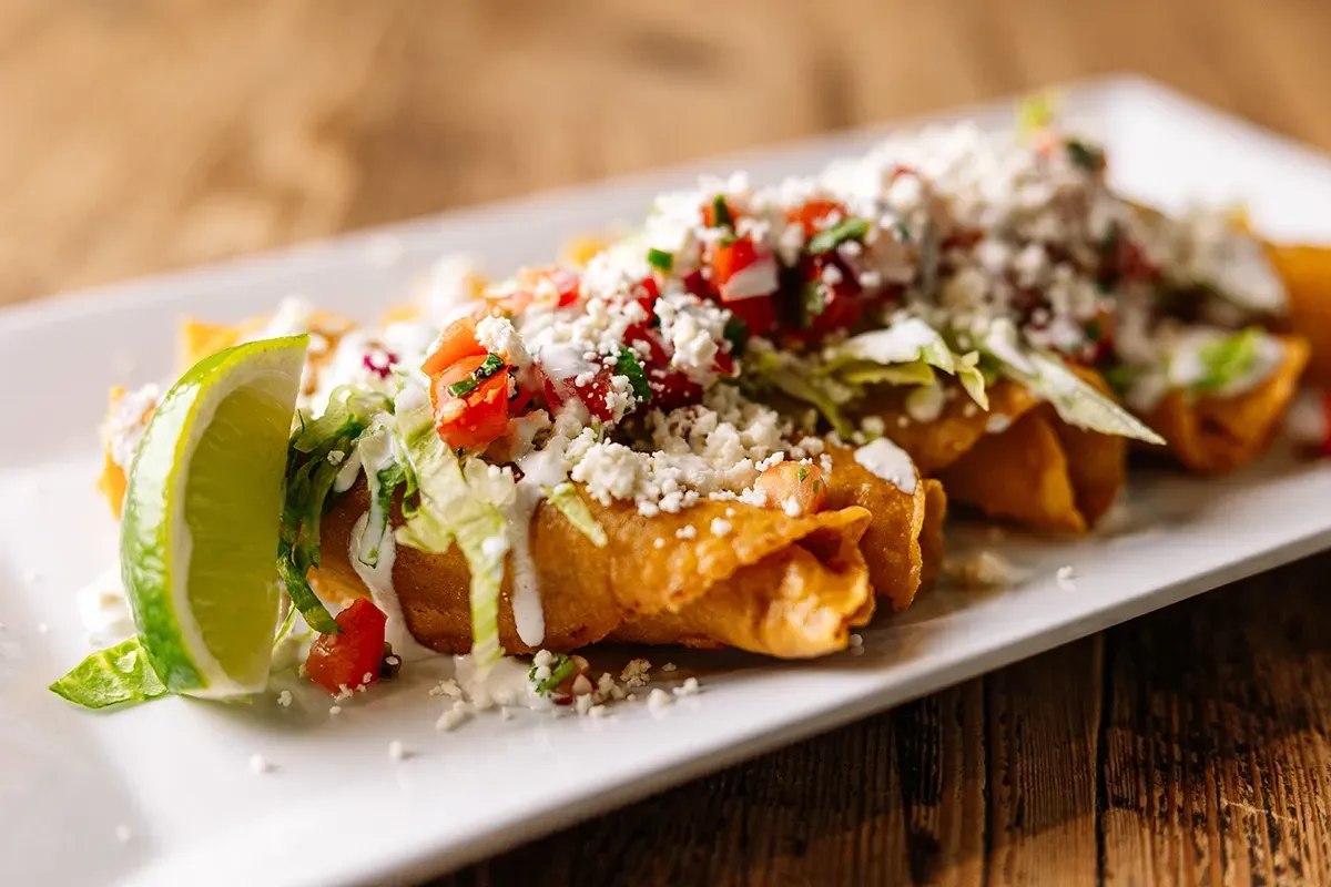 A close up of a plate of food on a wooden table.
