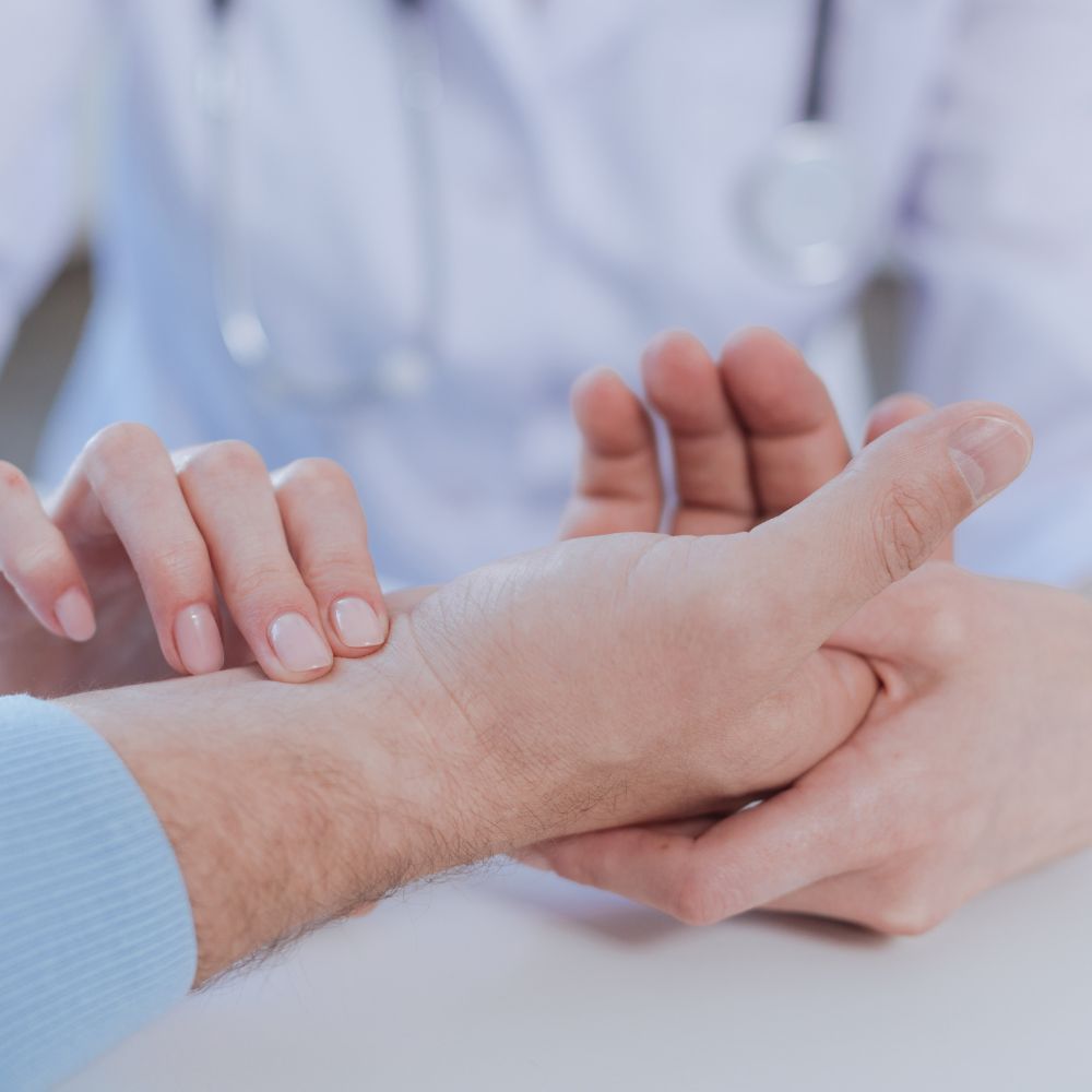 A doctor is examining a patient 's wrist with a stethoscope.