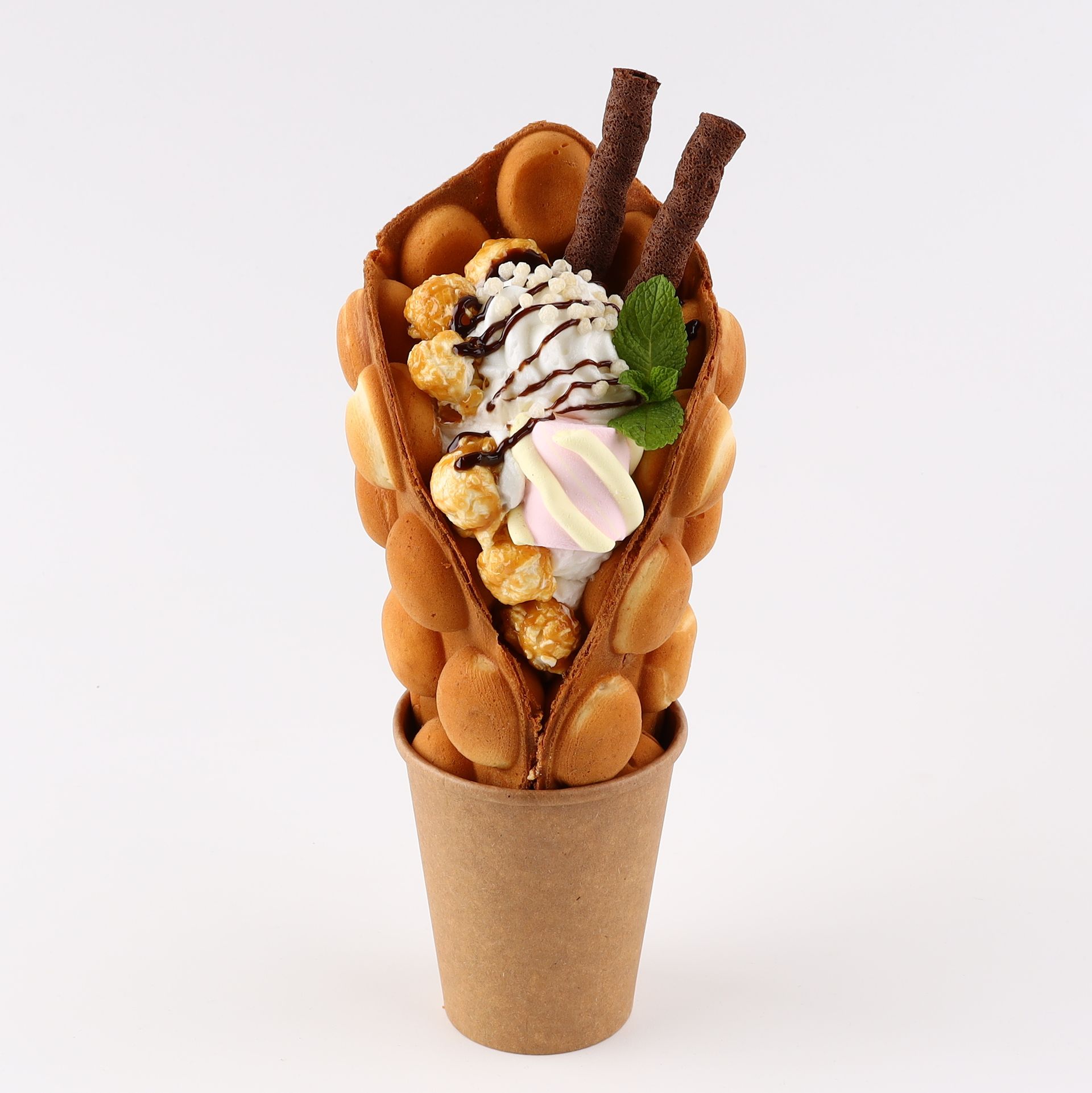 Bubble waffle cone filled with whipped cream, popcorn, chocolate sticks, and marshmallow.