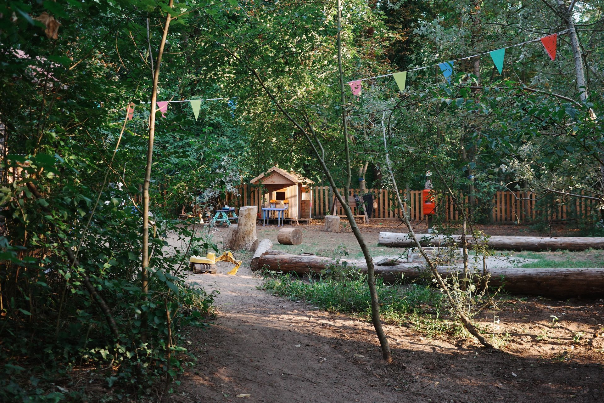 Kinderladen Waldgarten Feuerstelle mit Spielhaus