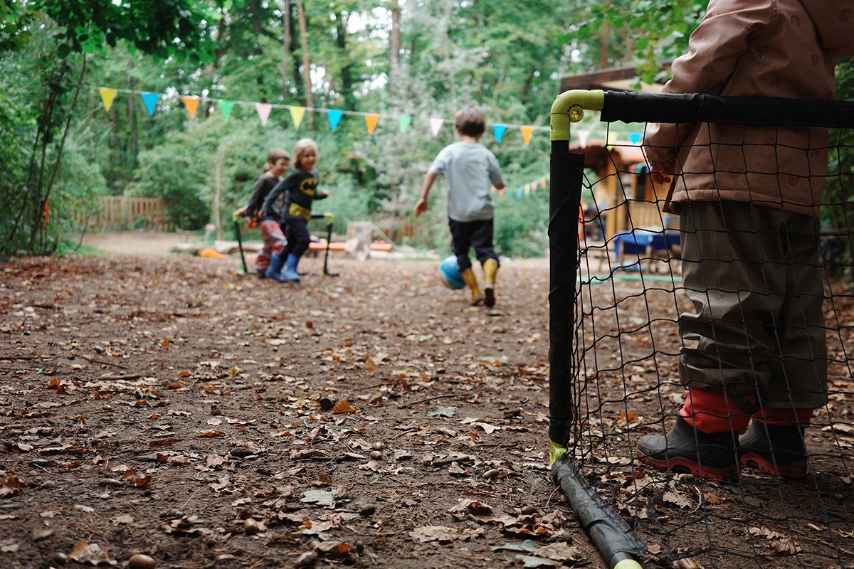 Kinder spielen im Waldgarten Fußball