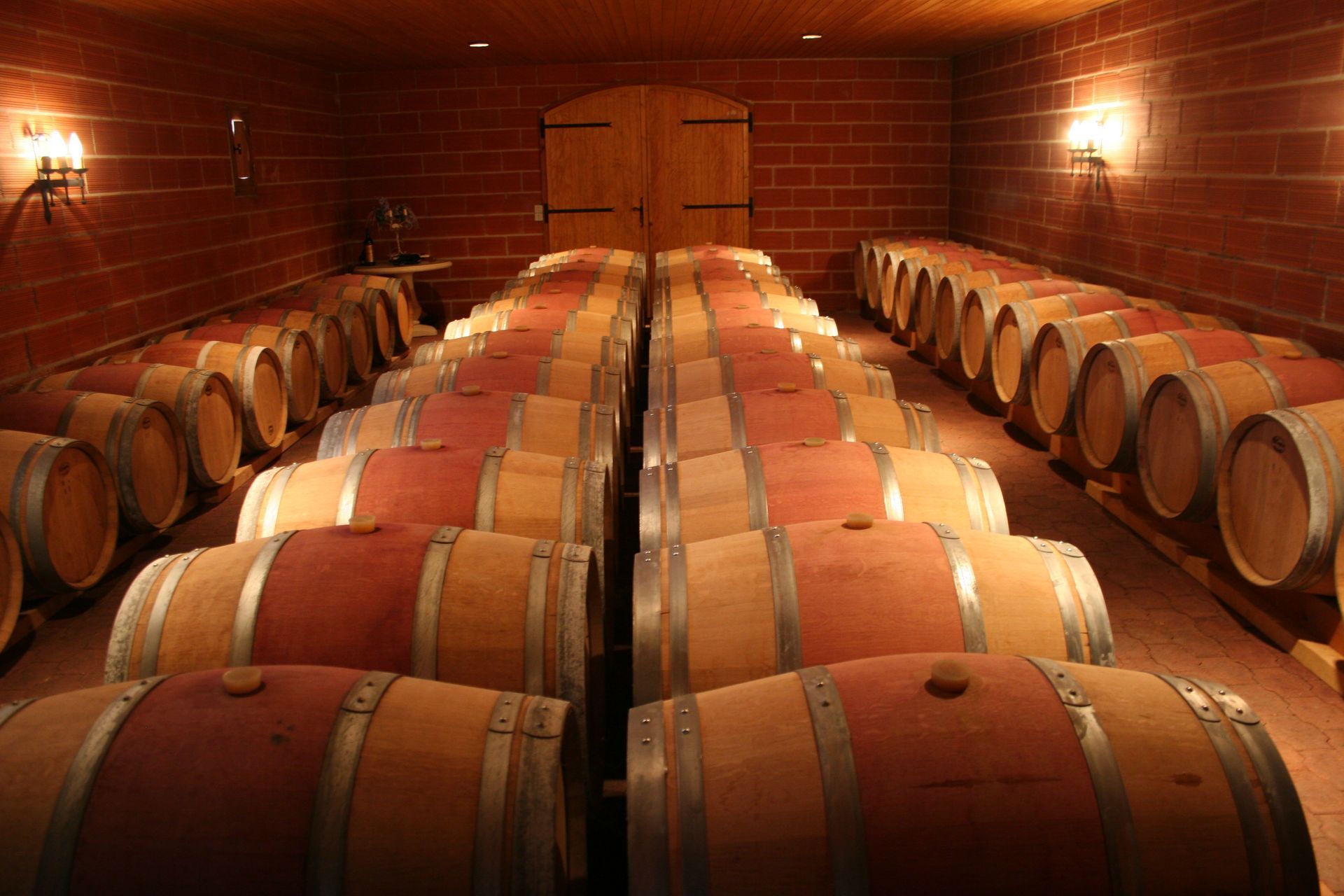 Une rangée de tonneaux de vin est alignée dans une cave à vin