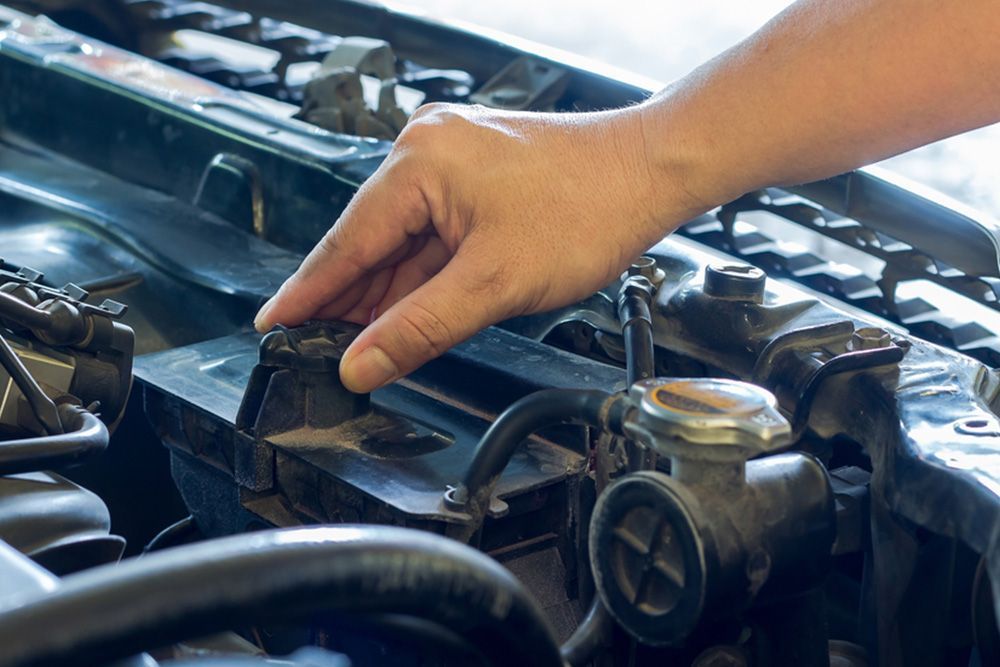 A Person Is Working On A Car Engine With A Multimeter — Auto Electrical & Air Conditioning in Gunnedah, NSW