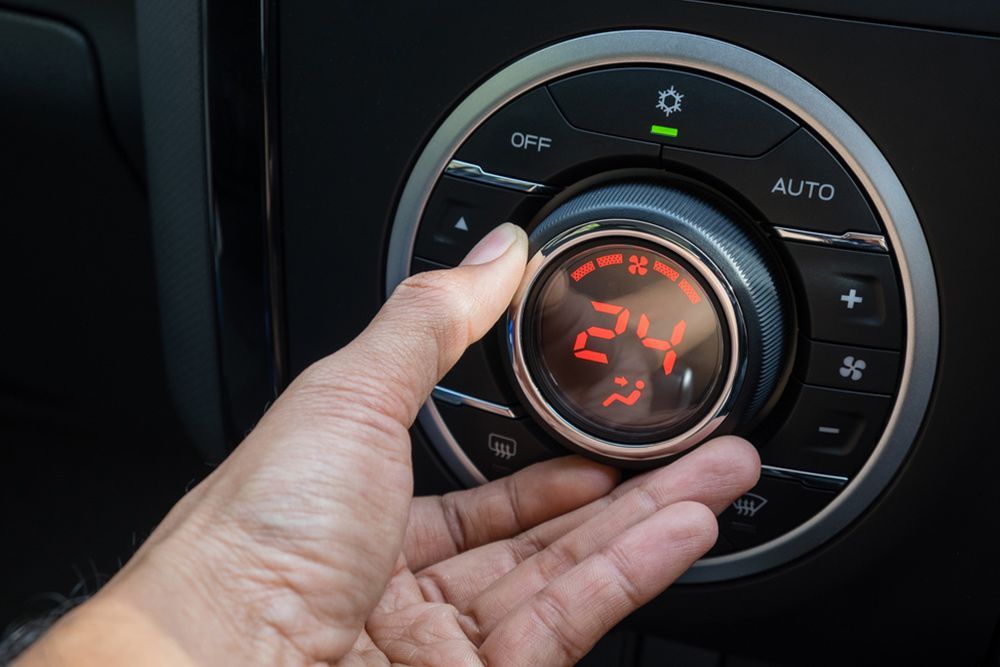 Person adjusting the temperature on a car's air conditioning system — Auto Electrical & Air Conditioning in Tamworth, NSW