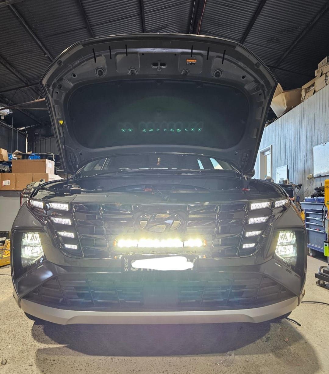 Black SUV With Hood Open, Led Light Bar on Front, Garage Setting