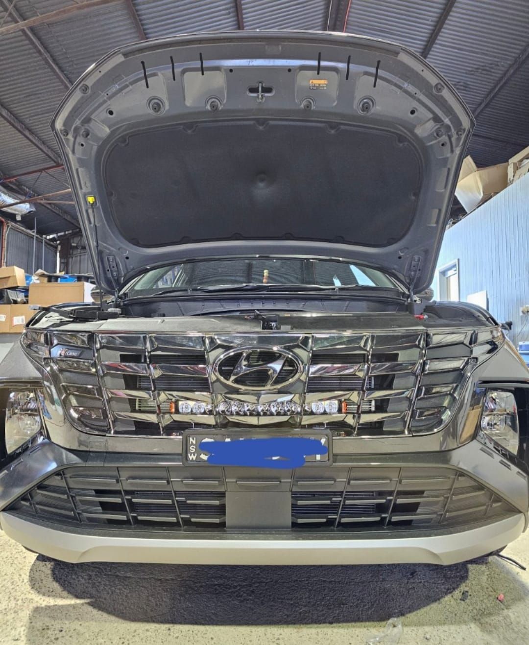 Black SUV With Hood Open, Led Light Bar on Front, Garage Setting