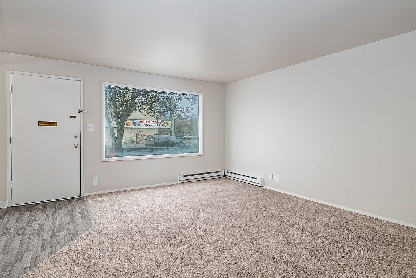 Photo showing a living room with a large window allowing for plenty of natural lighting