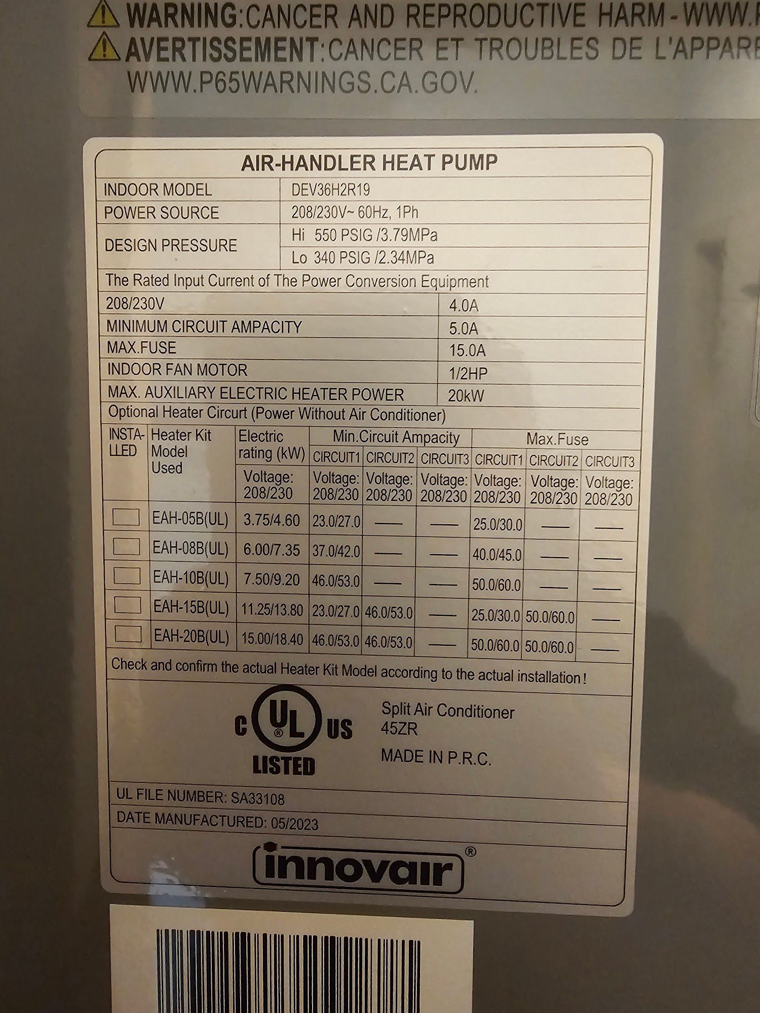Close-up of a silver label on an air handler heat pump, listing specifications and warnings.