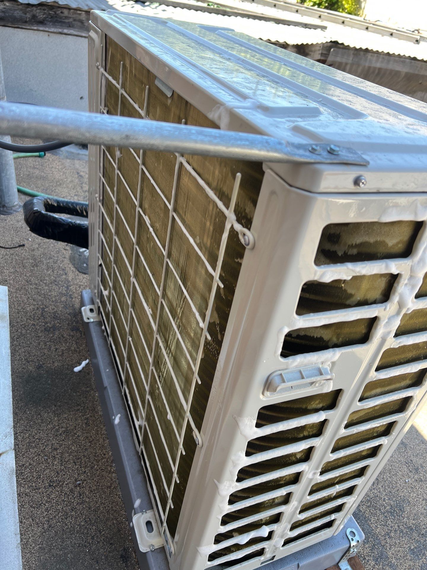 Outdoor air conditioning unit with metal grates and coils.