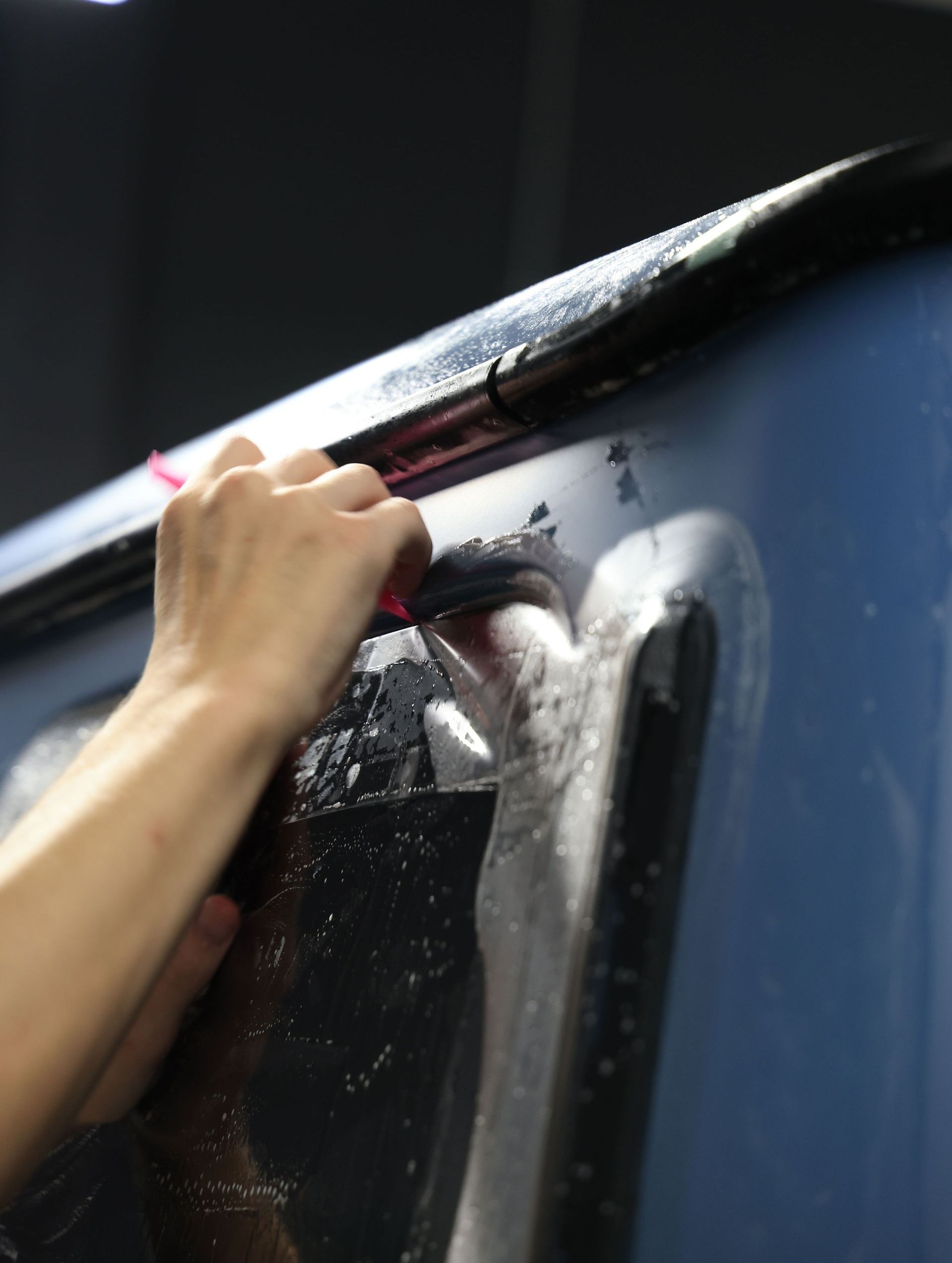 A person is cleaning a window with a brush.