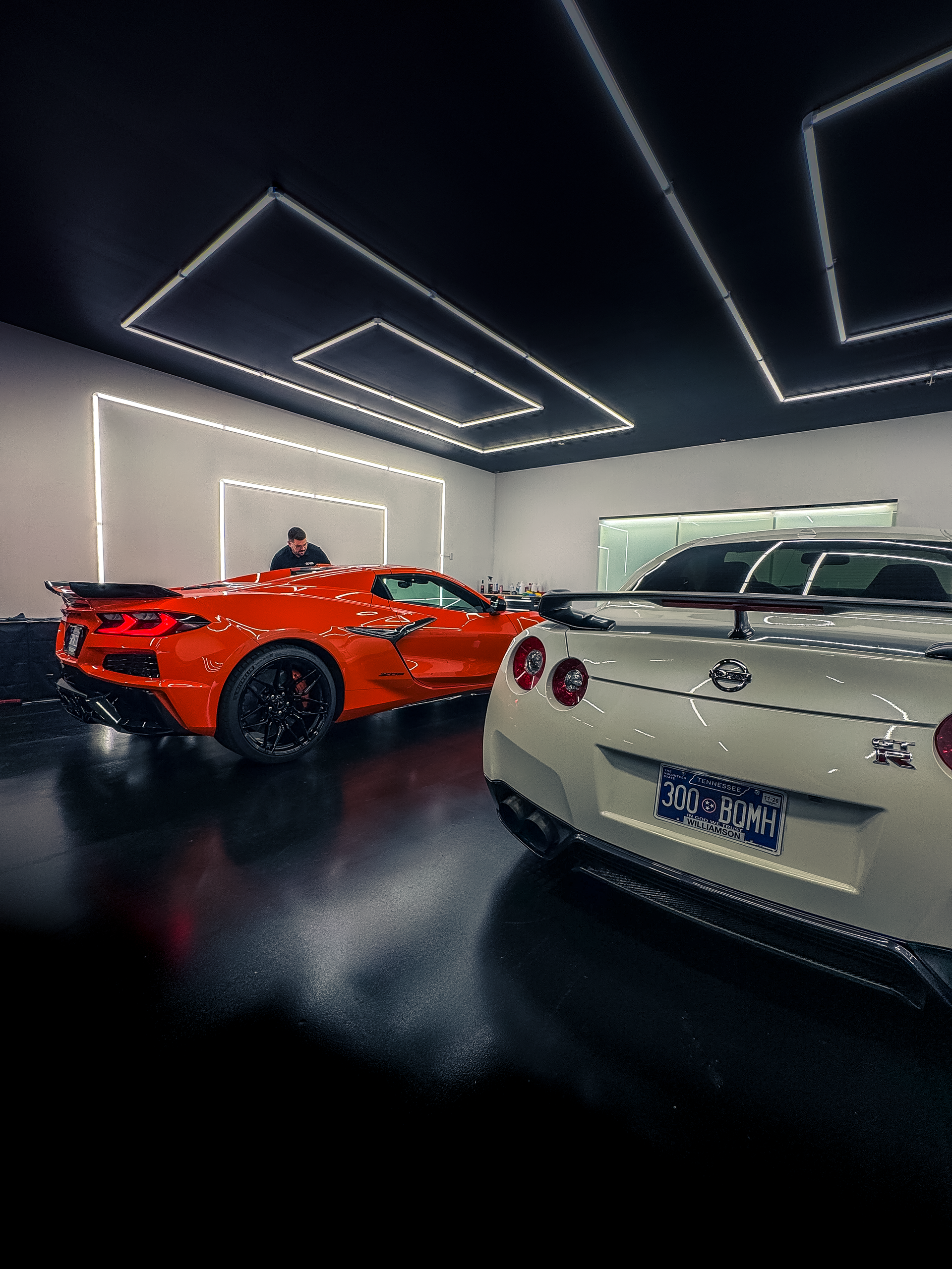 A red sports car is parked on the side of a road.