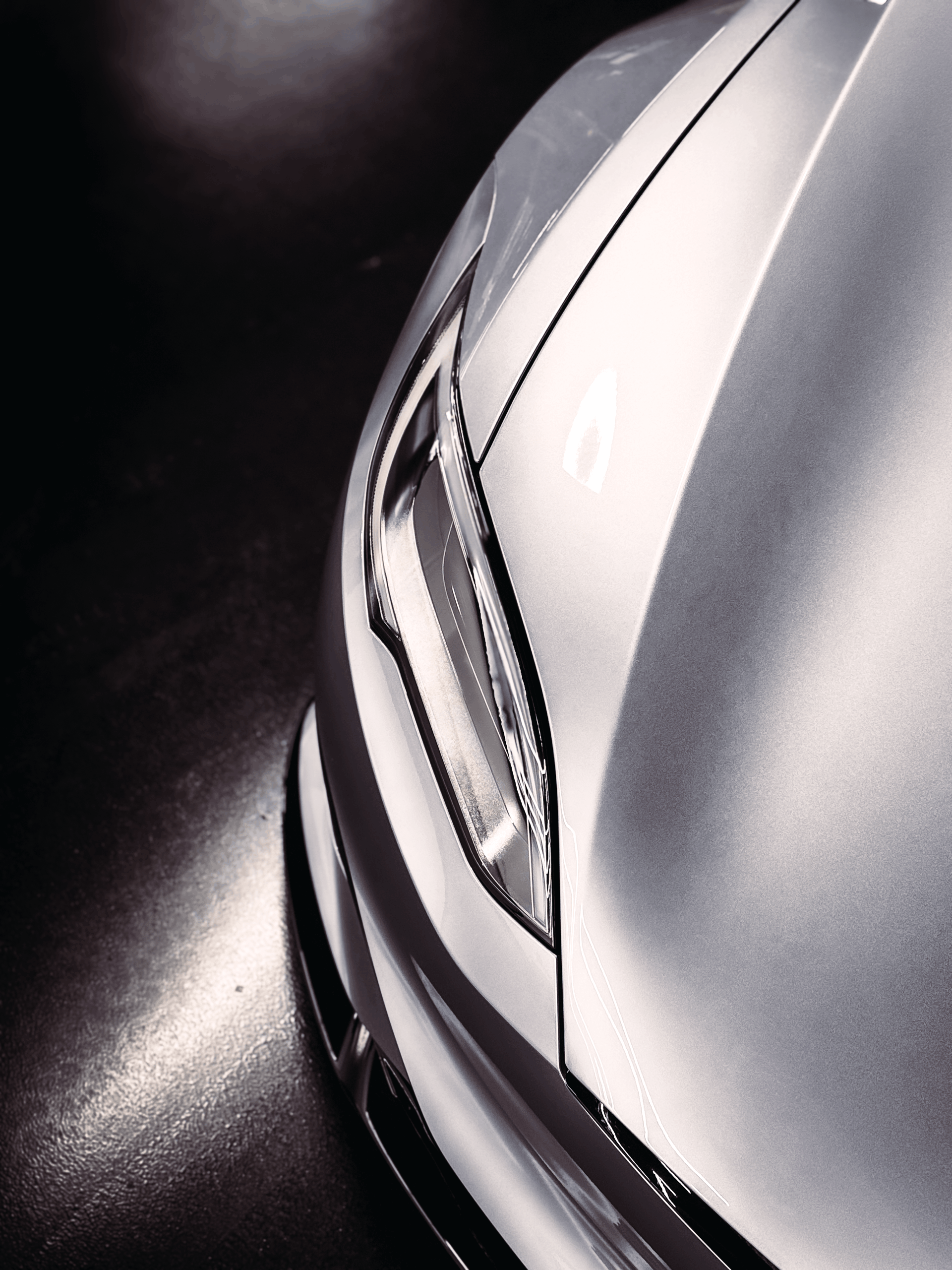 A black car is parked on the side of the road.