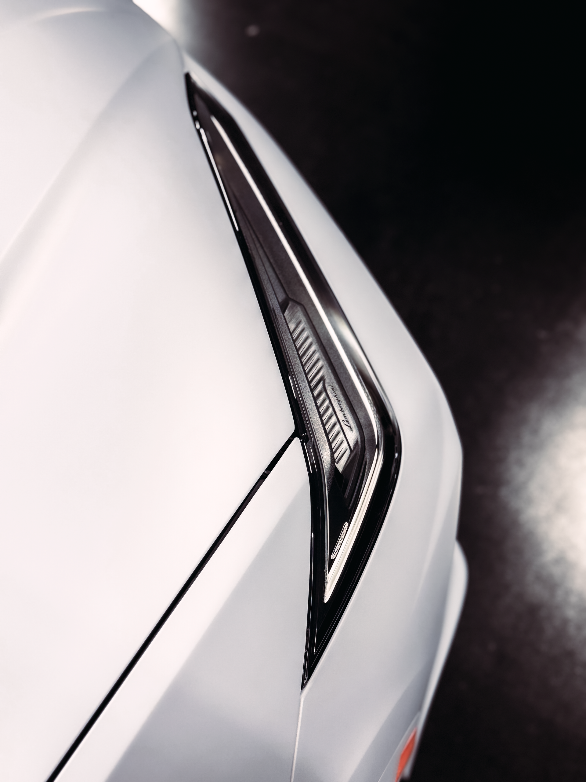 A blue tesla model 3 is parked in a garage.