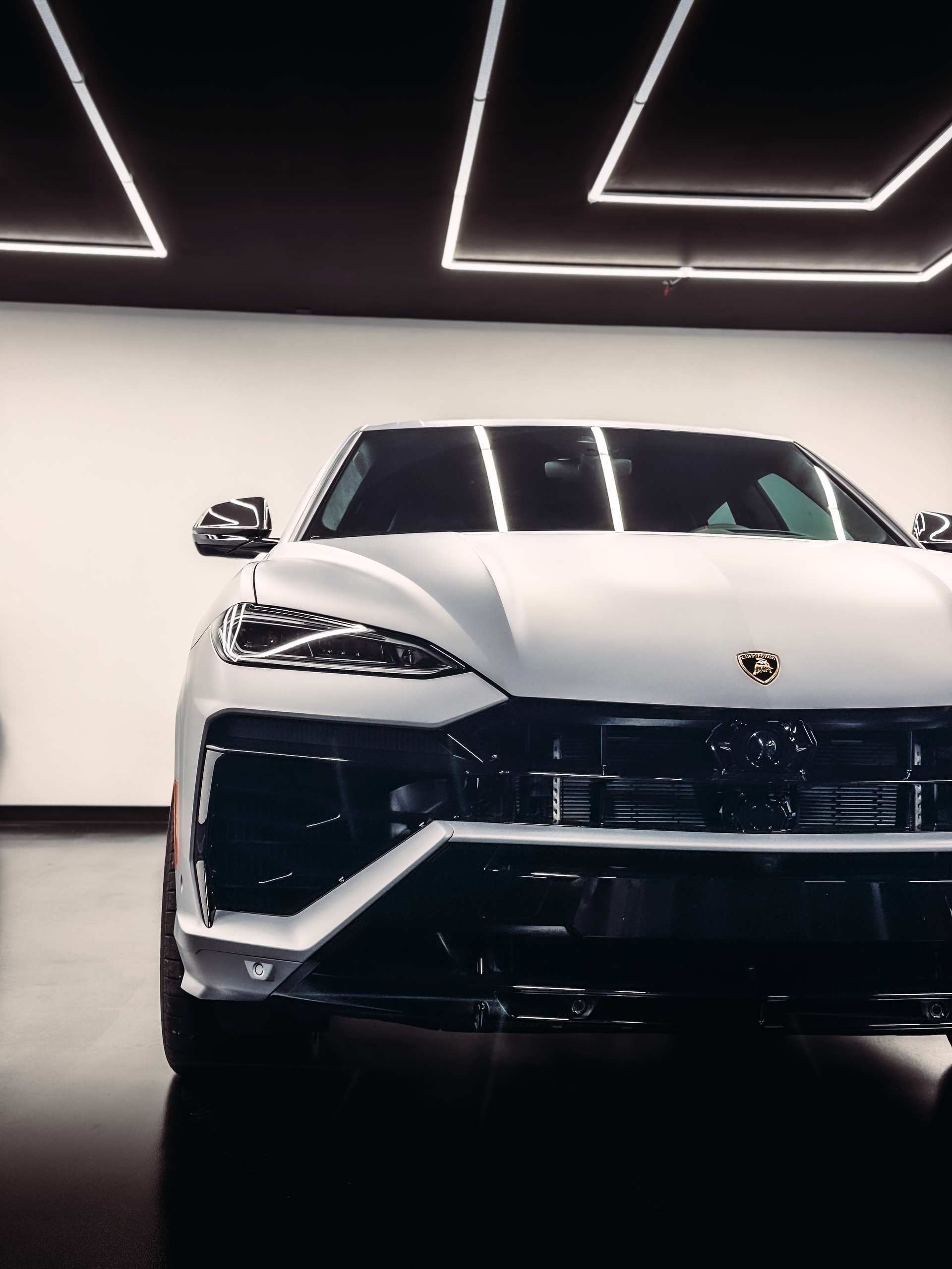 A man is cleaning a car in a garage.