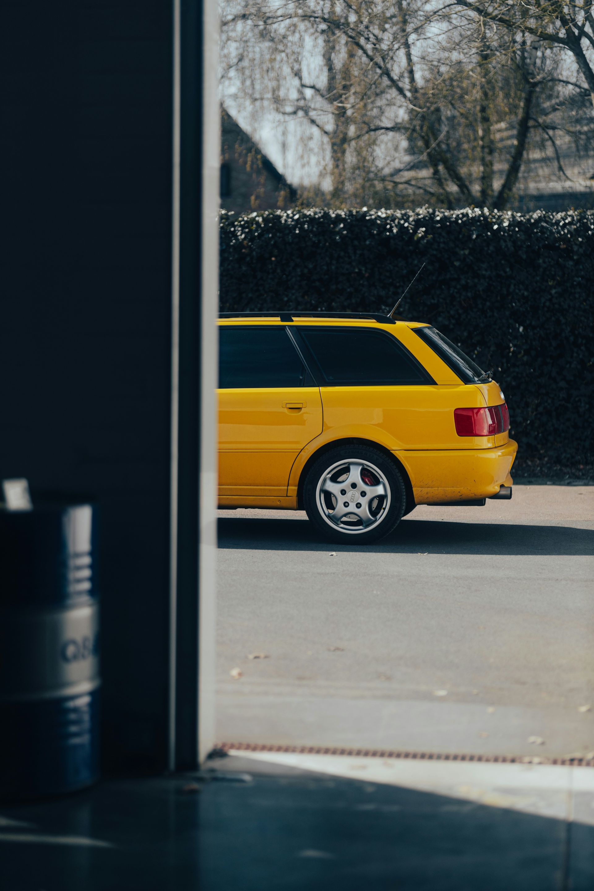 A yellow car is parked in a garage doorway.
