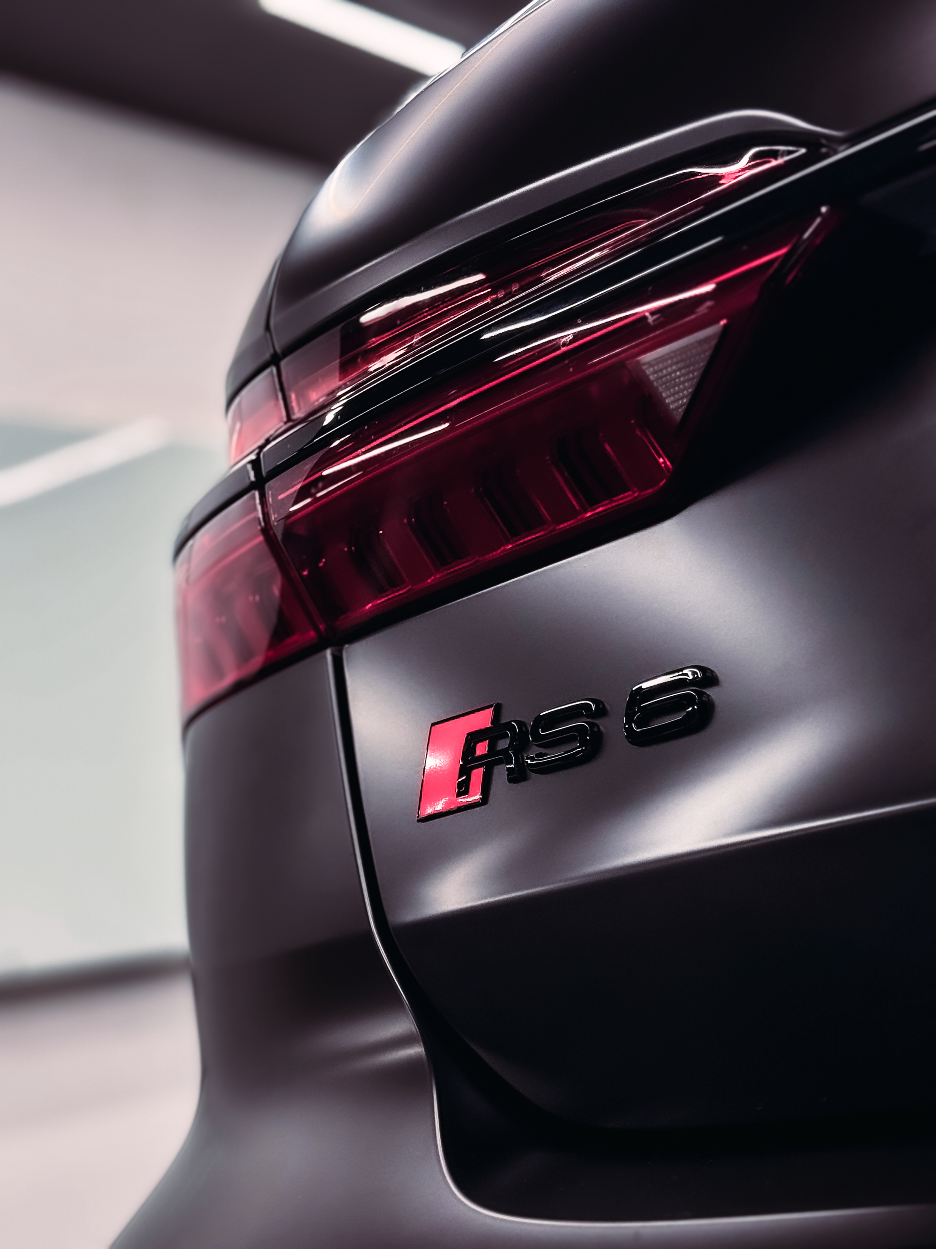 Two men are working on a car in a garage.