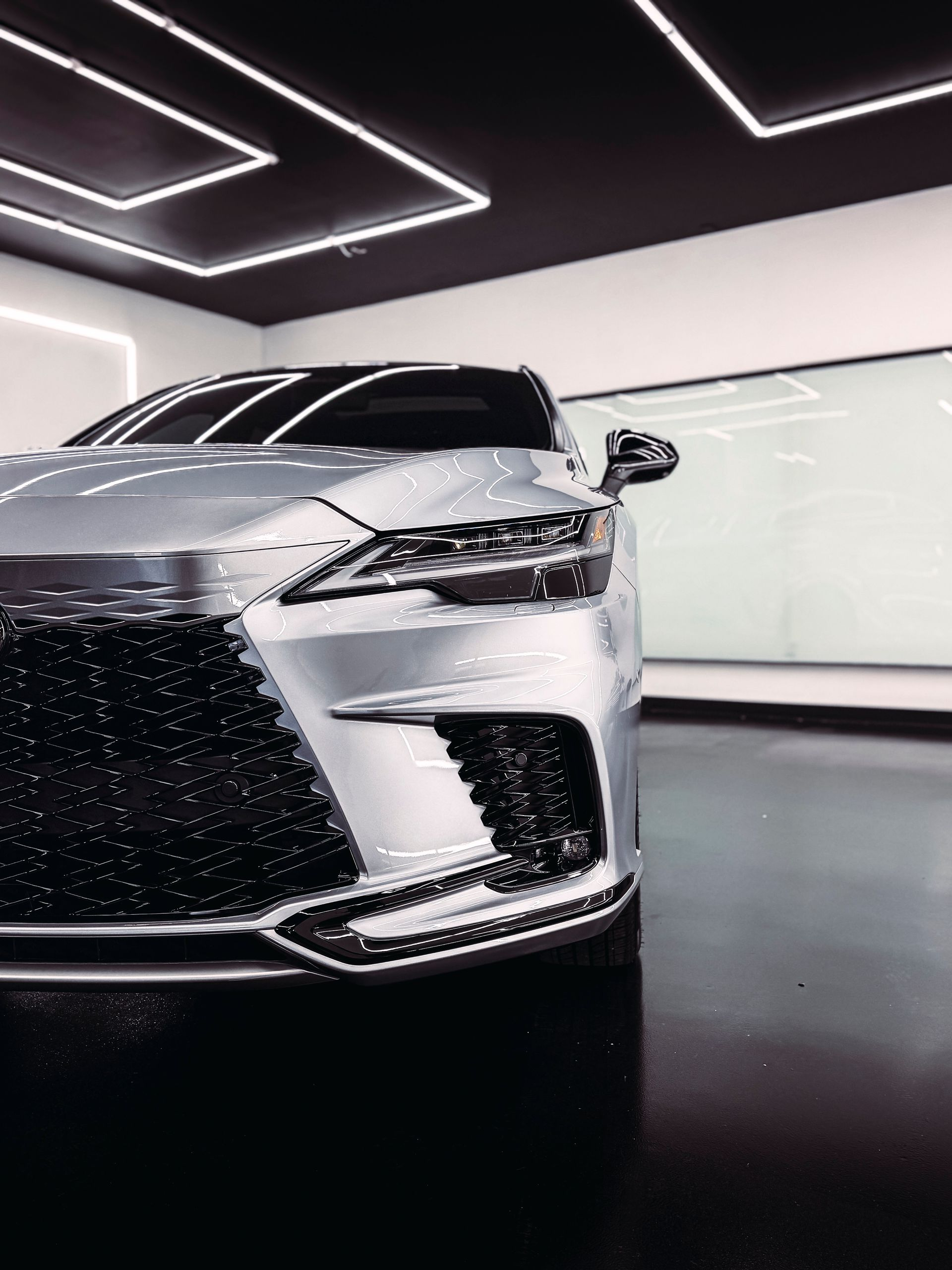 Silver Lexus SUV in a brightly lit showroom.