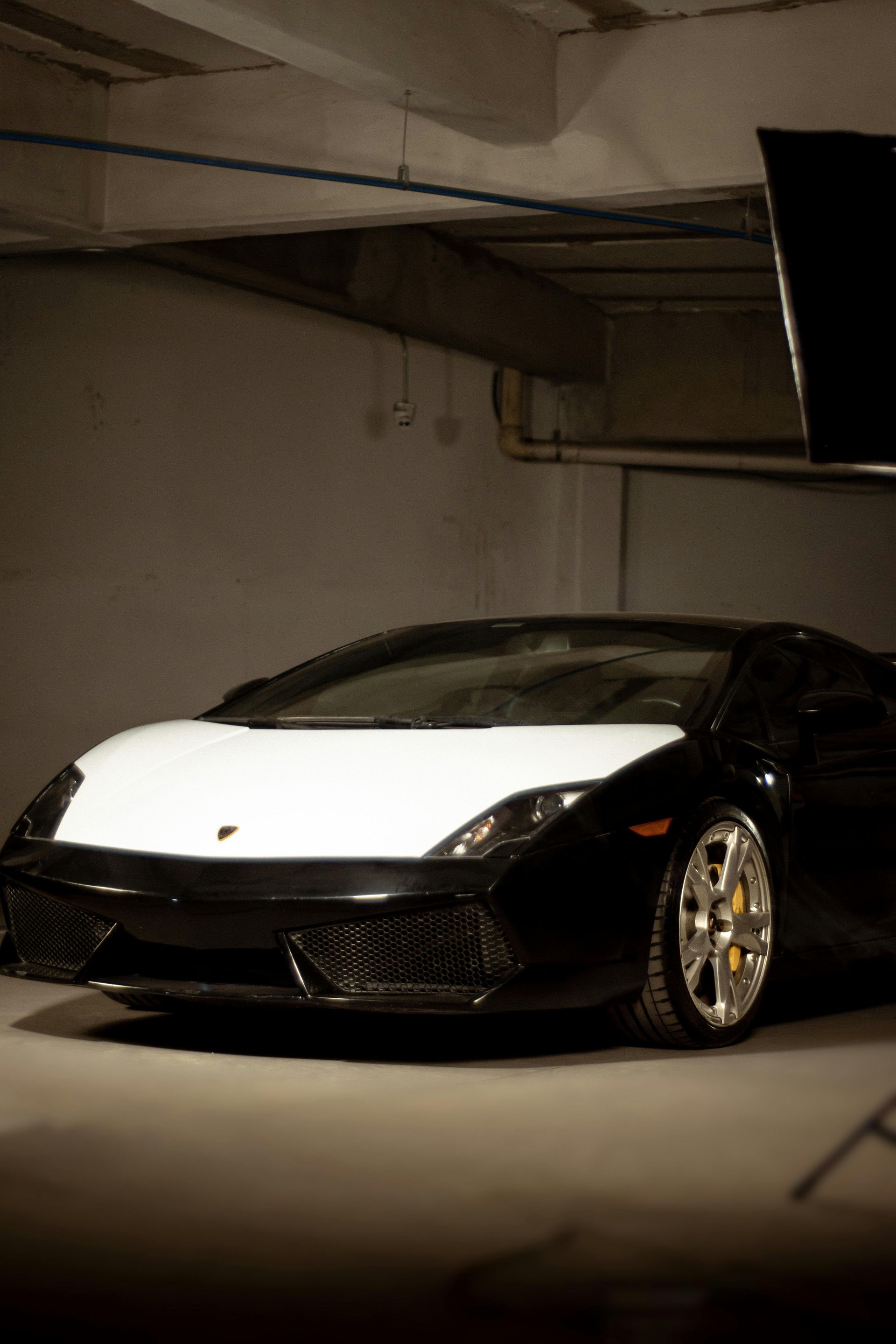 A black and white sports car is parked in a garage