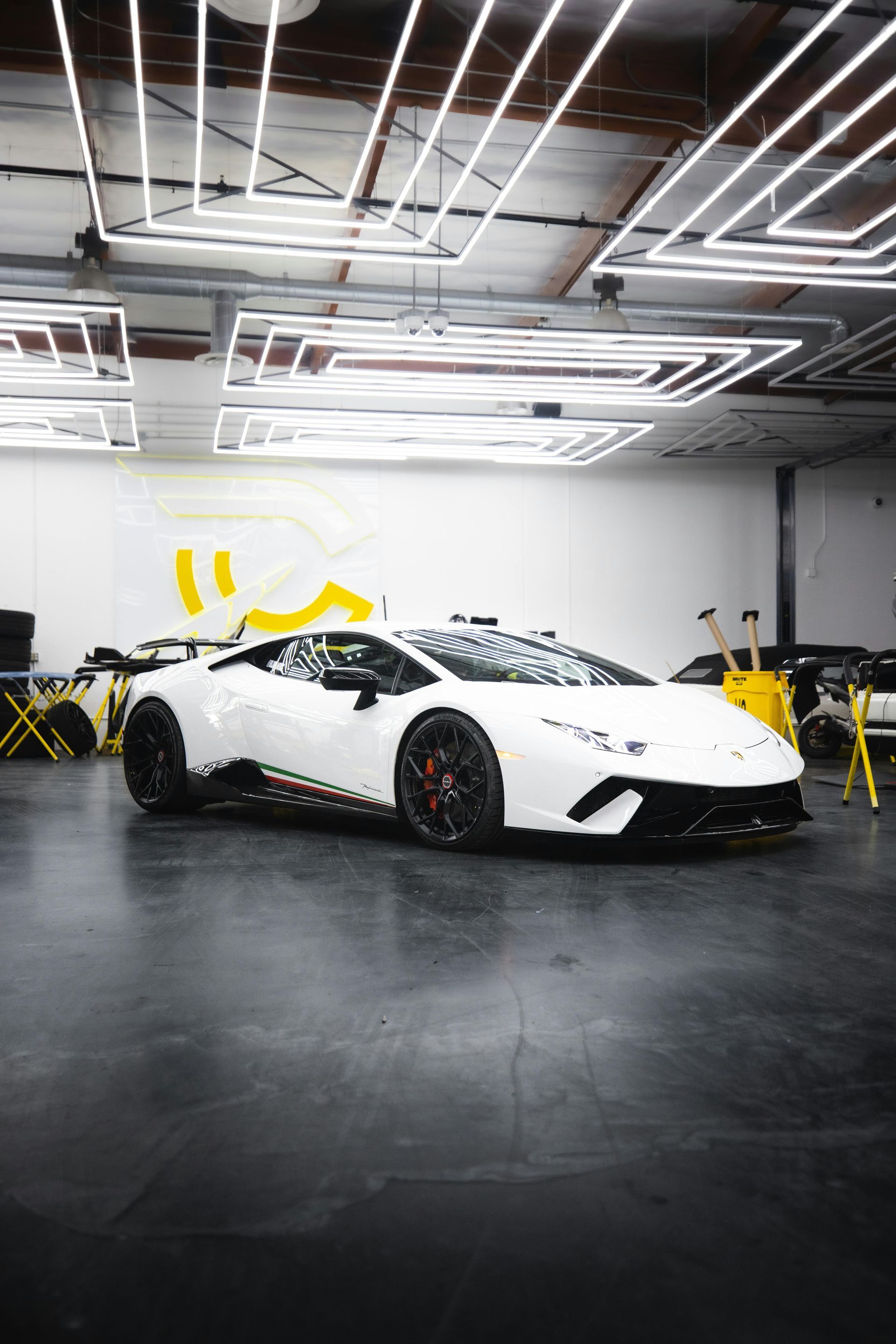 A white lamborghini huracan is parked in a garage.