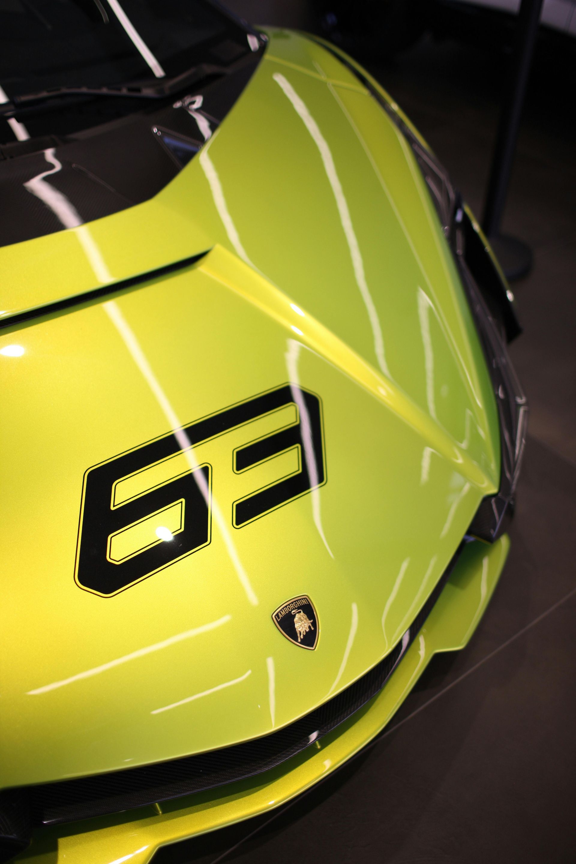 A yellow sports car with the number 63 on the front