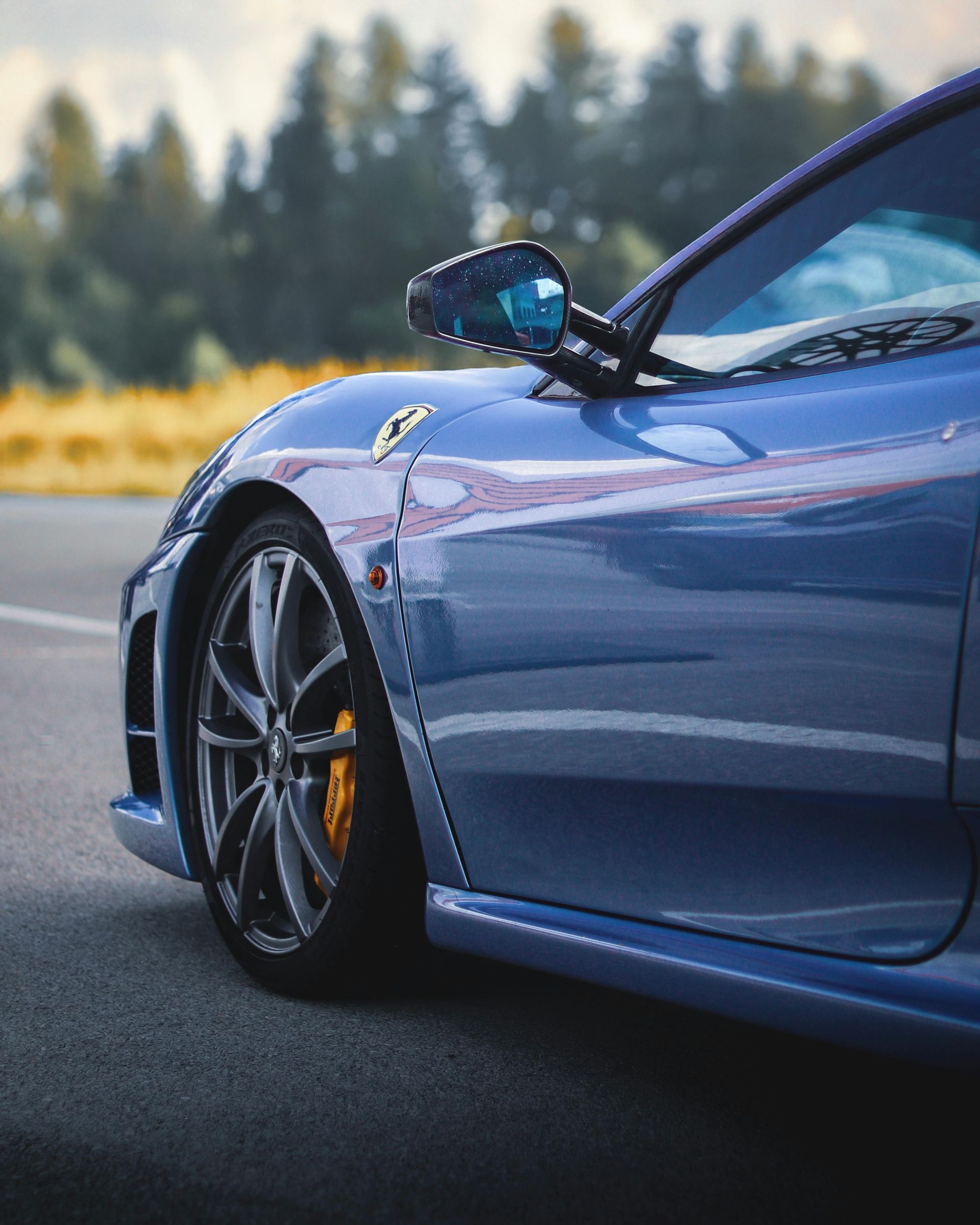 A blue sports car is parked on the side of the road