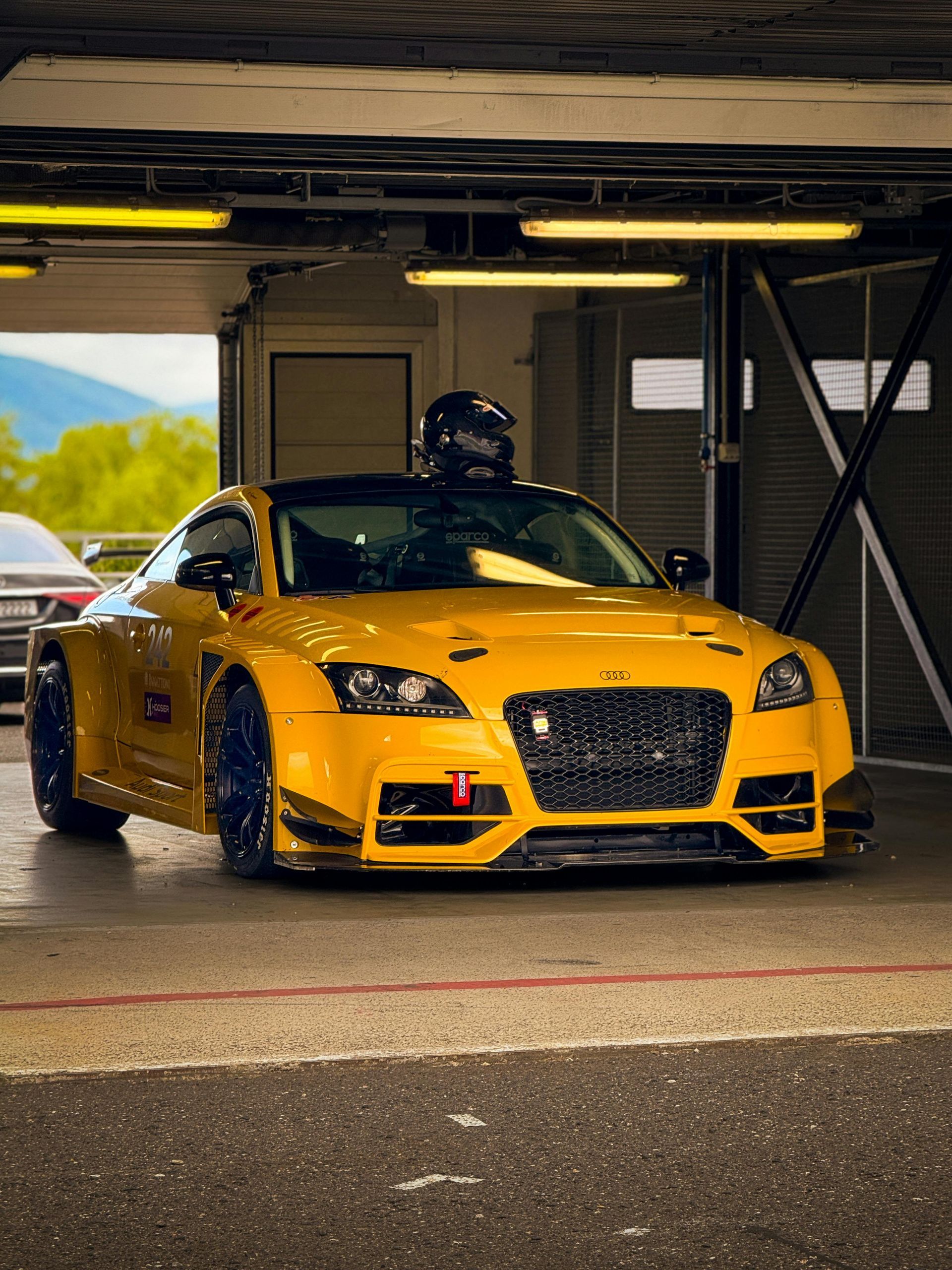 A yellow sports car is parked in a garage.