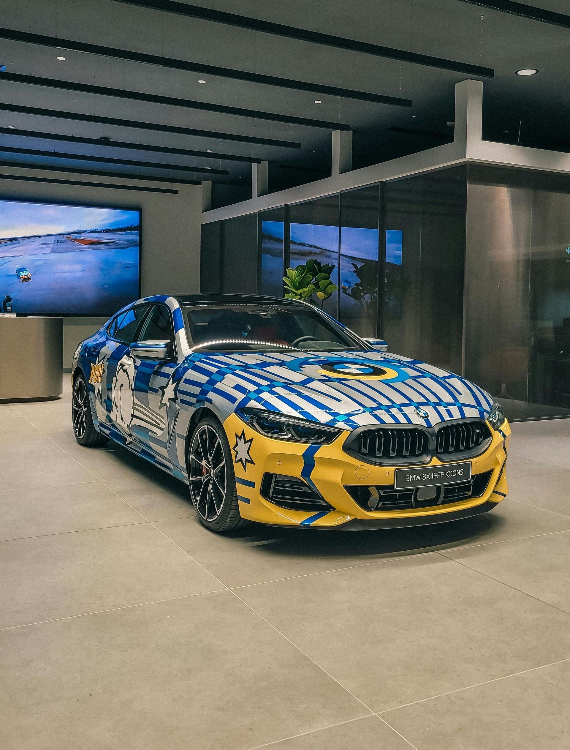 A blue and yellow sports car is parked in a building.