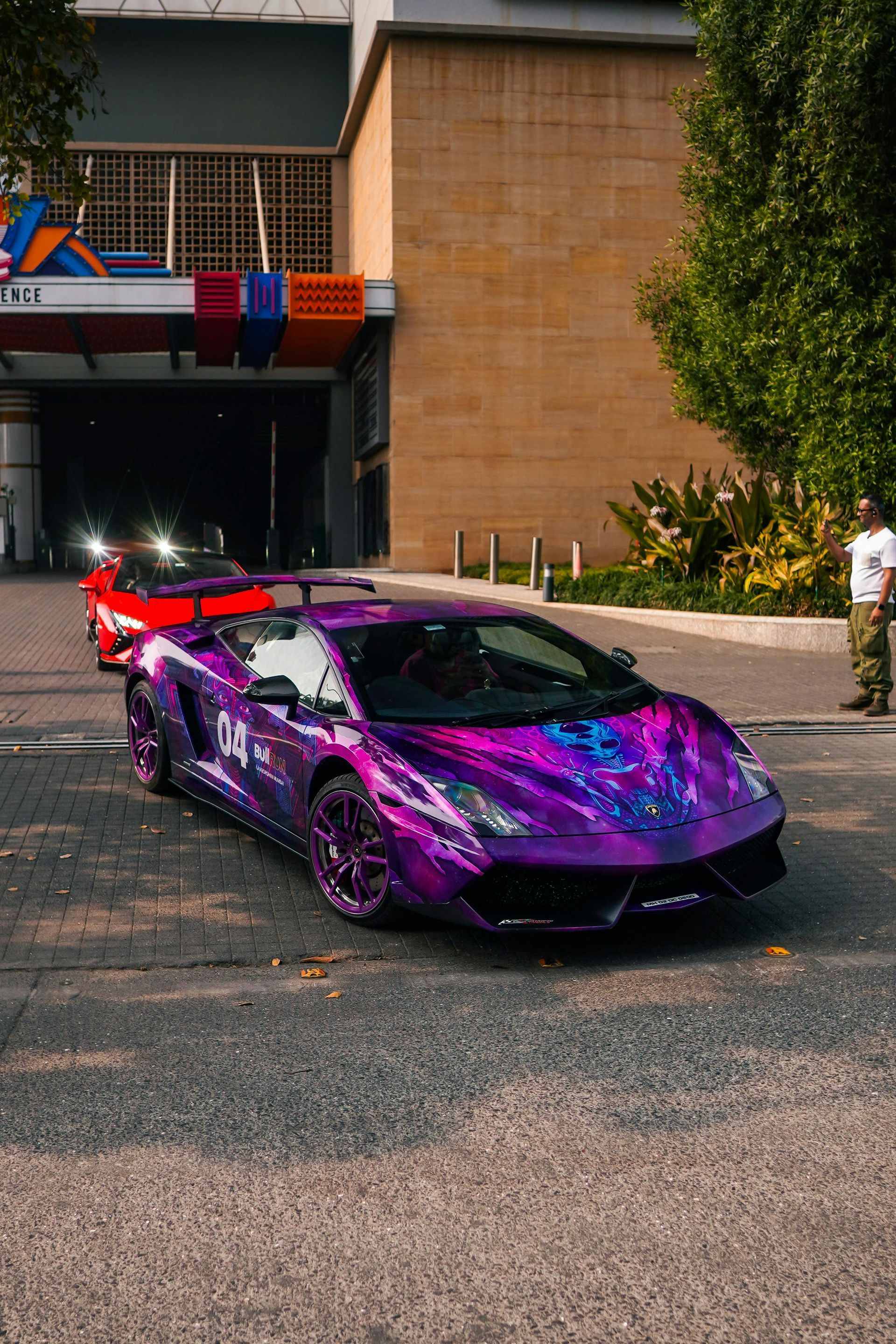 A purple lamborghini is parked in front of a building.