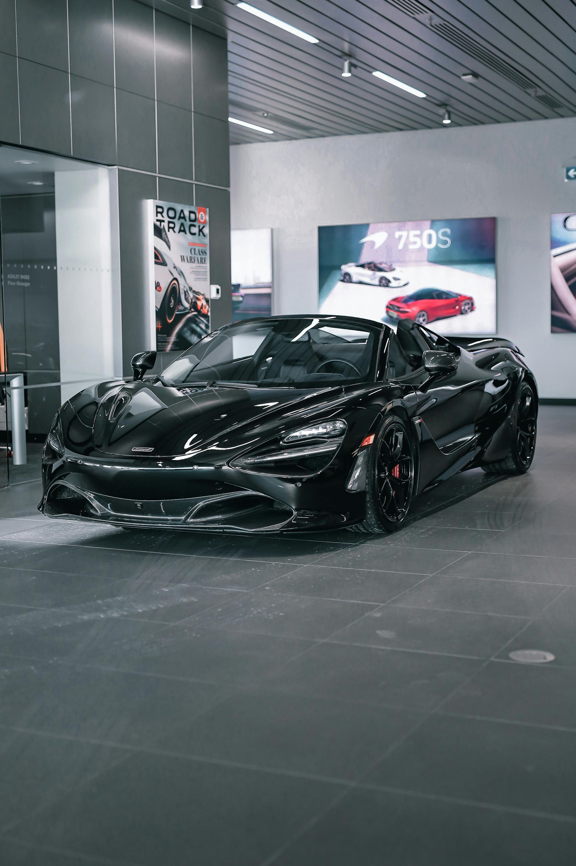 A black sports car is parked in a showroom.