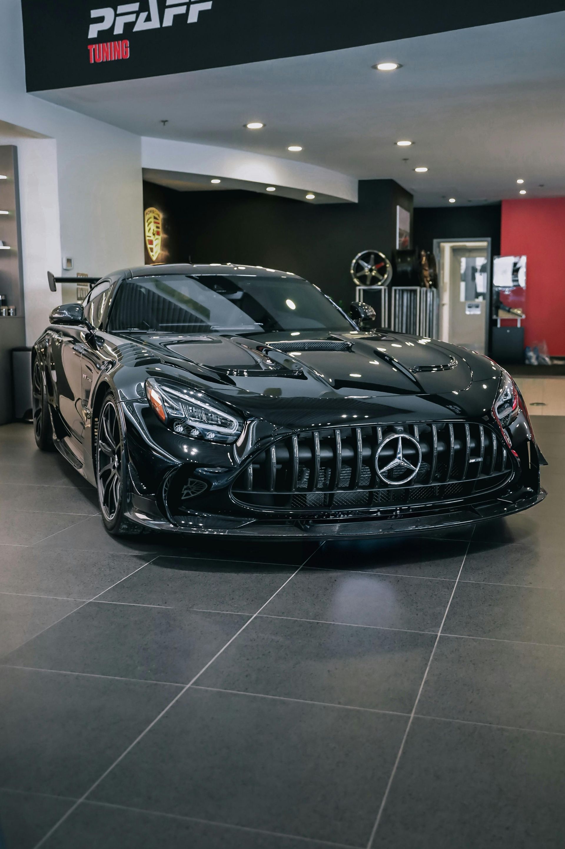 A black sports car is parked in a showroom.