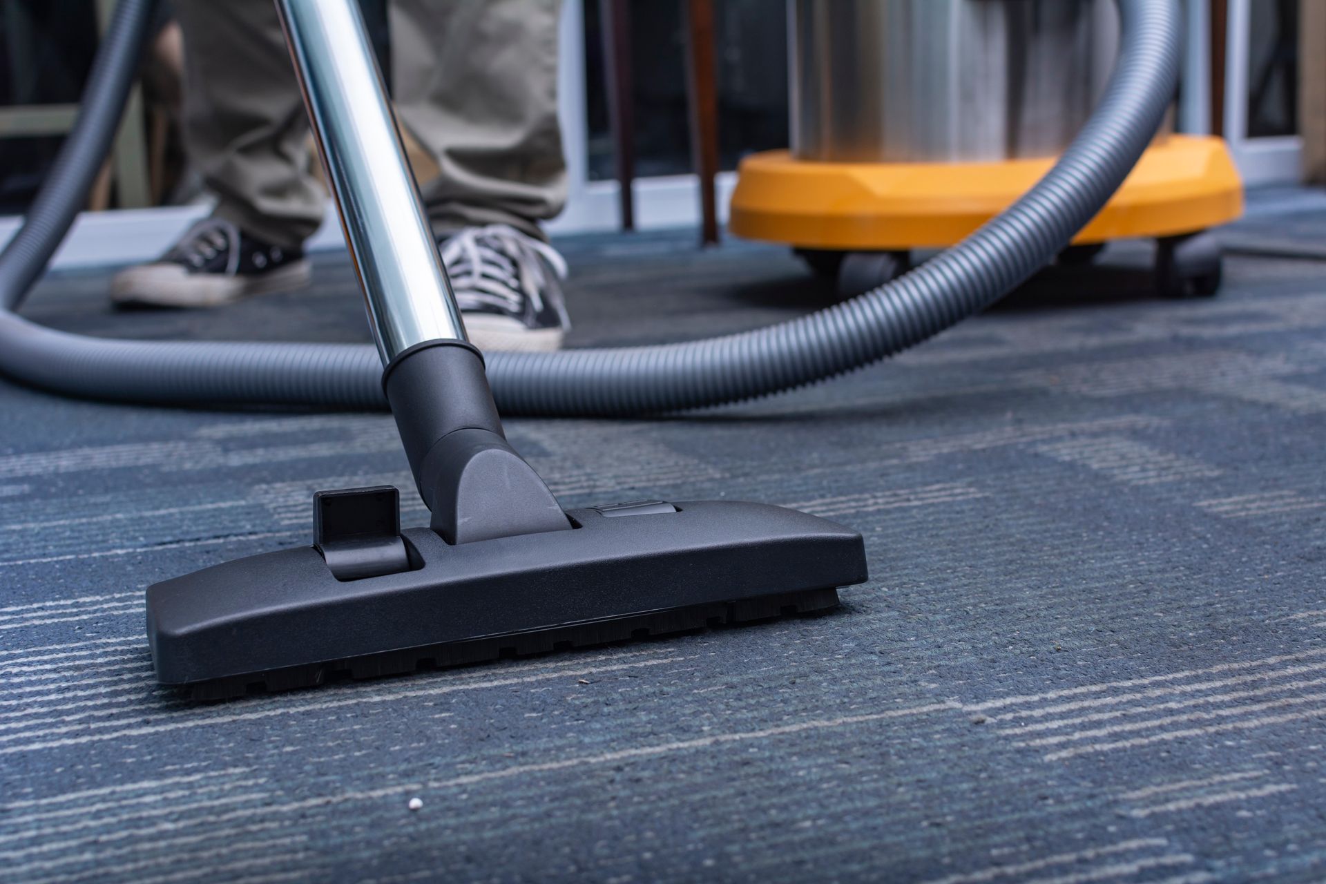 Vacuum cleaner nozzle on a carpeted floor in an office setting