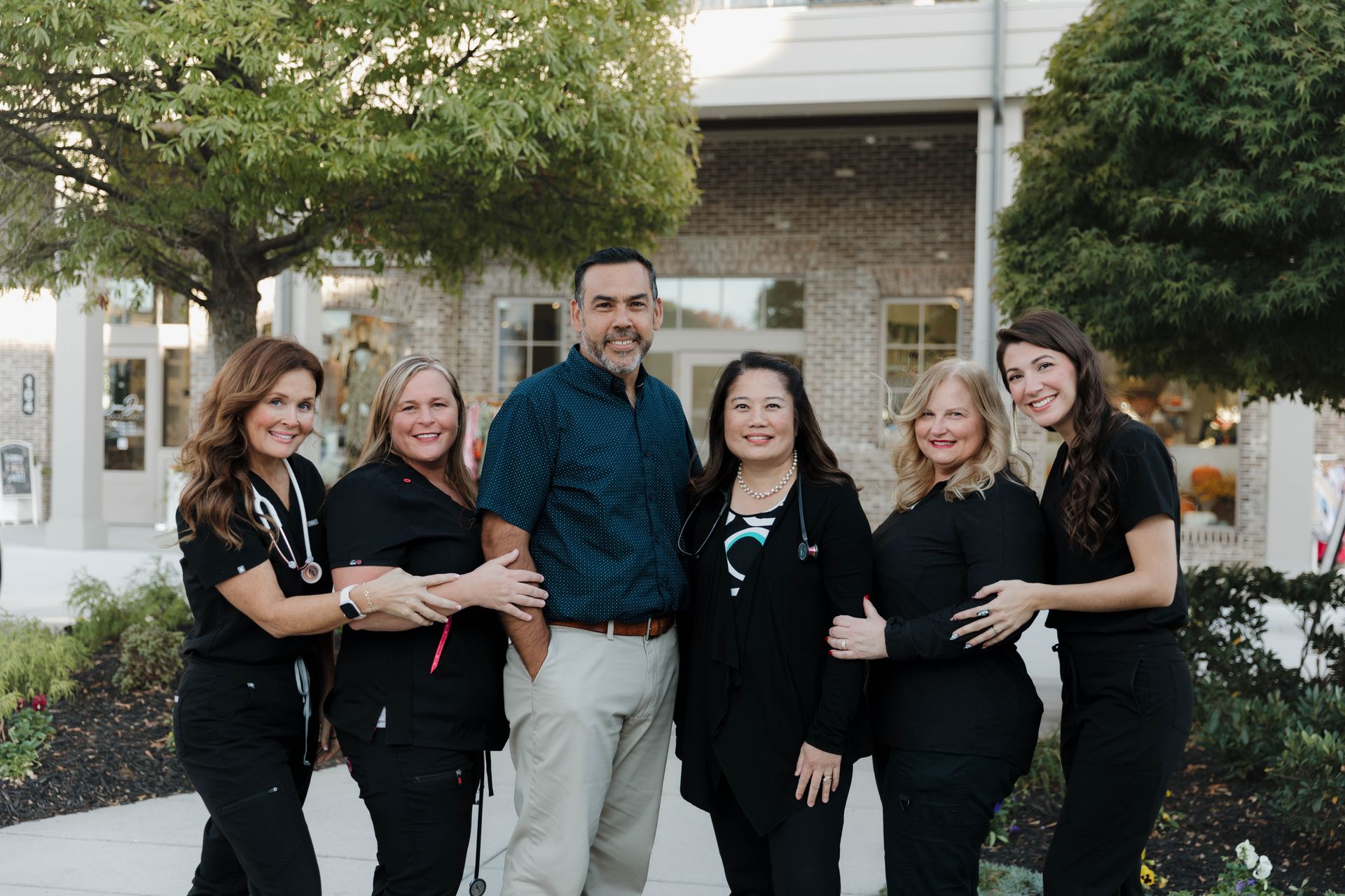 A group of people are posing for a picture in a park.