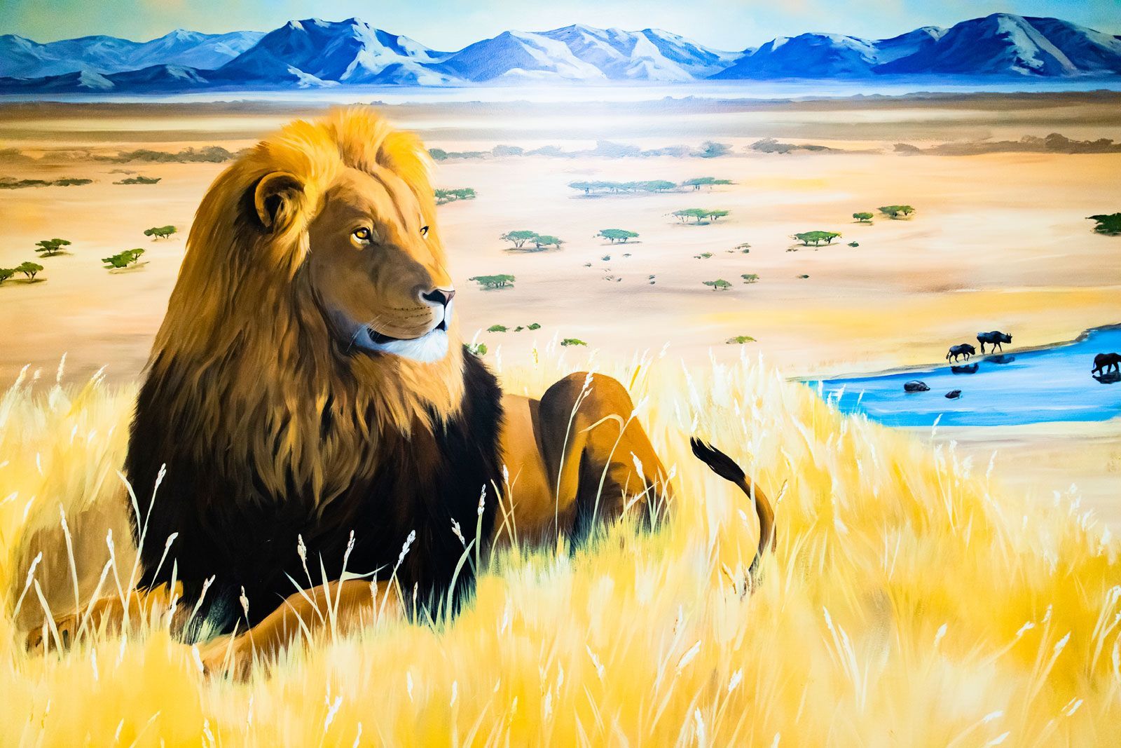 A painting of a lion laying in the grass with mountains in the background.